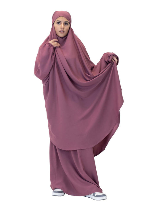 Person wearing a mauve abaya on a white background