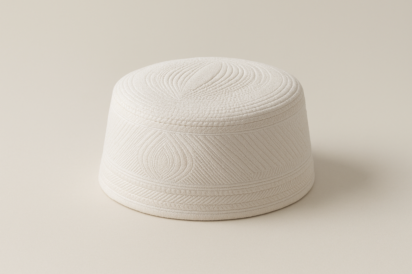A minimalist product photo of a men’s Islamic prayer hat (kufi/taqiyah), placed on a neutral background. The hat should have fine stitched detailing with elegant texture, simple and modest design, photographed in soft natural lighting, professional studio style, high resolution, ecommerce product photo.